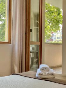 旧扎戈拉City Centre Bright & Cozy Apartment for 4 persons的窗户旁的一张带毛巾的床