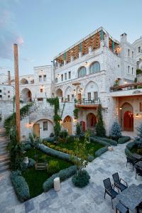 奥塔希萨尔艾科拉卡帕多西亚酒店的一座大型石头建筑,前面设有花园