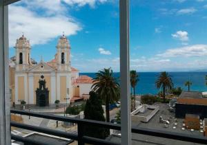 休达帕拉多尔楚塔酒店的从窗户可欣赏到教堂和大海的景色
