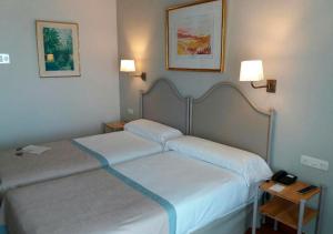 休达帕拉多尔楚塔酒店的配有2盏灯的酒店客房的2张床