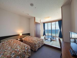 恩纳Hotel Miyuki Beach的酒店客房设有两张床和一个阳台。