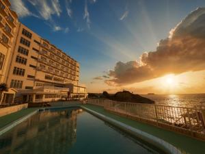 恩纳Hotel Miyuki Beach的酒店游泳池的背景是大海