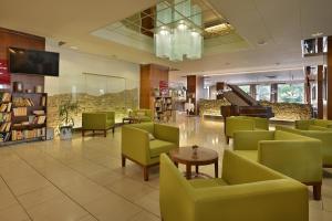 贝龙里塔瓦贝龙大酒店的一间设有绿色椅子和钢琴的等候室
