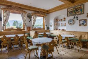 科尔蒂纳丹佩佐阿根廷别墅酒店的用餐室设有桌椅和窗户。