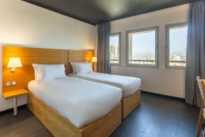 拉巴特麦地那瑞贝特奥莫酒店的一间卧室设有一张大床和两个窗户。