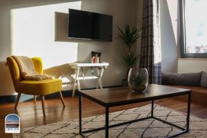 奥本Oban Bay Apartments的客厅配有电视、桌子和椅子