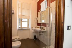 比萨7间房住宿加早餐旅馆的一间带卫生间、水槽和镜子的浴室