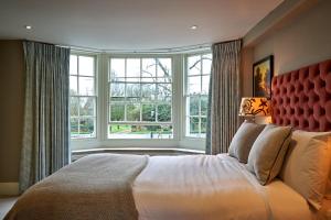 Charlton马和马夫酒店的一间卧室设有一张大床和大窗户