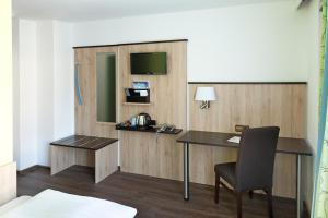 上施莱斯海姆蓝鲤鱼酒店的客房设有书桌、椅子和电视。