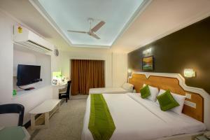加尔各答Treebo Trend Green View的一间酒店客房,配有一张床和一台电视