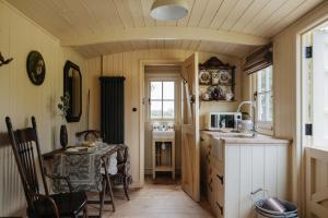 Ormesby Saint MichaelThe Shepherds Huts at Ormesby Manor的一间带桌子和微波炉的小厨房