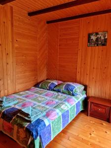 斯拉夫西克Приватна Садиба Потічок的木制客房内的一间卧室,配有一张床