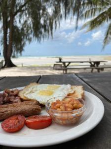 达累斯萨拉姆Mikadi Beach Camp & Backpackers的包括鸡蛋香肠和西红柿的早餐食品