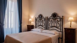 拉奎拉Palazzo dei Pavoni, Relais di Charme的一间卧室设有一张大床和两个床头柜
