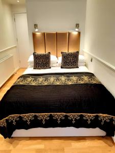 伦敦拉什莫尔酒店的卧室配有一张大床,提供黑色床单和枕头。