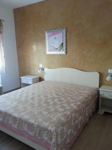 圣伊西多罗B&B sul Mare的卧室配有一张床,墙上挂着一幅画
