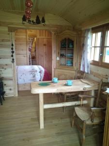LessiveAu Paradou du Bûcheron Adults only的木制客房配有桌子和床。