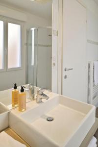 利勒鲁斯Residence Des Îles的白色的浴室设有水槽和镜子