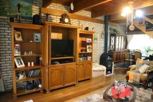卡内拉Sítio Dos Amigos的一间客厅,客厅内配有一台电视,位于一个木制娱乐中心