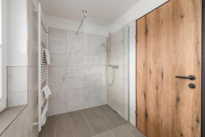 普鲁格恩Landgasthof Bierfriedl的带淋浴的浴室和木门