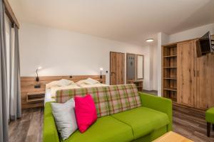 普鲁格恩Landgasthof Bierfriedl的客厅配有绿色沙发和床。