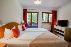 柯尼希斯湖畔舍瑙Der Lärchenhof Ferienwohnungen的一间卧室设有两张床、一台电视和窗户。