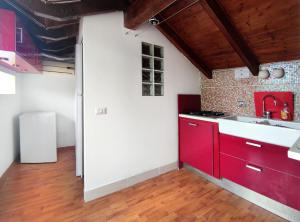 诺利La vita è bella - Noli的一间带红色橱柜和水槽的厨房