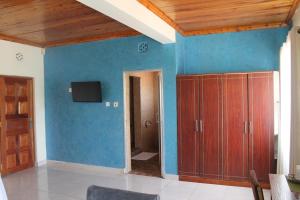 内罗毕Masai Game Resort的客厅拥有蓝色的墙壁和木制天花板。
