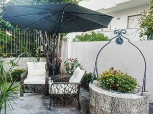 普拉亚·阿马勒B&B Villa dei Desideri的庭院配有桌子、遮阳伞和椅子