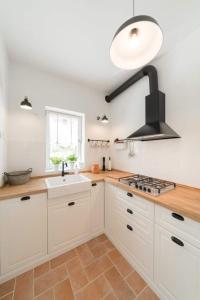 帕格Beach House Mela的厨房配有白色橱柜、水槽和炉灶。