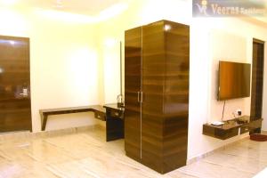 蓬蒂切里Veeras Residency的一间带大型木制橱柜和电视的浴室