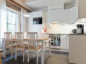 锡尔卡Holiday Home Taruilevi 10 j2 by Interhome的厨房配有白色橱柜和木桌及椅子