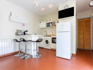 乐巴凯尔斯Apartment Les Cabestans 1-2-3-4 by Interhome的厨房配有白色冰箱和2个吧台凳
