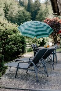 柯尼希斯湖畔舍瑙Der Lärchenhof Ferienwohnungen的庭院内桌椅和遮阳伞