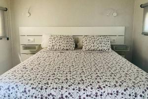 乌娜Cabaña El Verdinal的一间卧室配有一张带白色床罩和枕头的床。