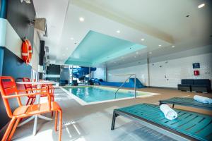 雅茅斯Tru By Hilton Yarmouth, Ns的游泳池,带橙色椅子的房间