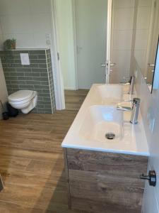霍勒姆Zonnehoeve vakantiehuizen的浴室配有白色水槽和卫生间。