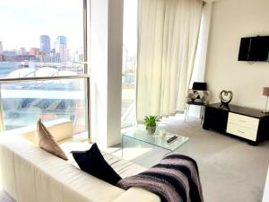 伯明翰Cityscape Apartment in Birmingham with Self Checkin的客厅配有白色沙发和大窗户