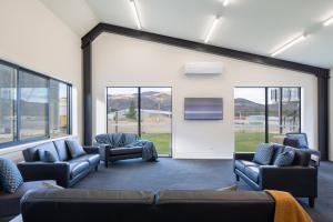 克伦威尔Harvest Park Studios Workers Accommodation的一间配有沙发、电视和窗户的等候室
