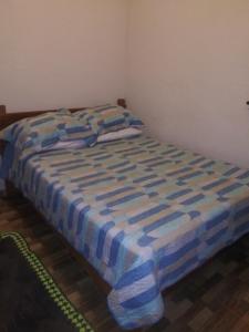圣安娜杜里亚舒Casa da Seriema em Lapinha da Serra的床上有蓝色和白色的毯子