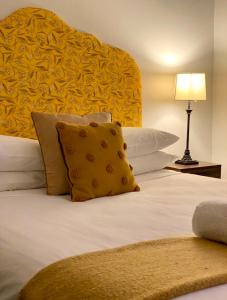 亚拉腊The Barkly Bistro Bar & Accommodation的一间卧室配有一张带黄色床头板的大床