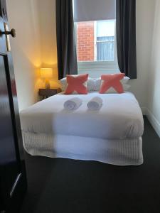 亚拉腊The Barkly Bistro Bar & Accommodation的卧室配有带粉红色枕头的大型白色床