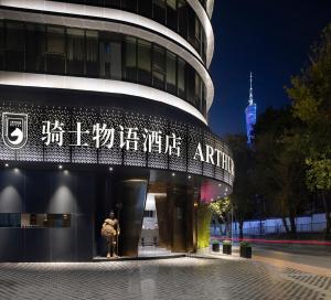 广州广州塔骑士物语酒店-Arthur Hotel Canton Tower Guangzhou的有一对夫妇在晚上站在建筑物外面