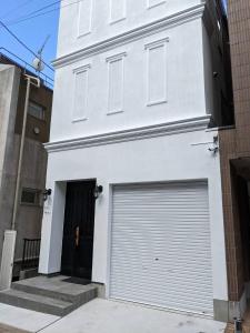 东京Villa Roppongi的白色的建筑,设有可移动的车库门