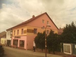 捷克斯卡利采Apartmány pod Barunčinou školou的街道边的粉红色和白色建筑