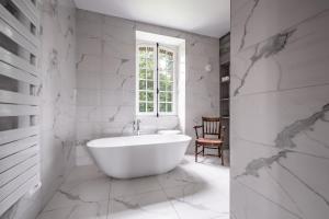 VillotranAu vieux Château的白色的浴室设有浴缸和窗户。