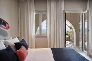 克里希阿克提帕罗斯岛波塞冬Spa酒店的一间卧室设有一张床和一个大窗户