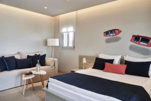 克里希阿克提帕罗斯岛波塞冬Spa酒店的一间卧室配有一张床和一张沙发
