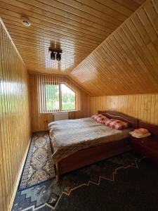 Berkhomet-pe-SiretКриївка у ставка的木制客房内的一间卧室,配有一张床
