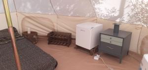 马里蒂玛Farm Glamping tent on Acquaviva Bay的帐篷内配备了冰箱和炉灶的房间